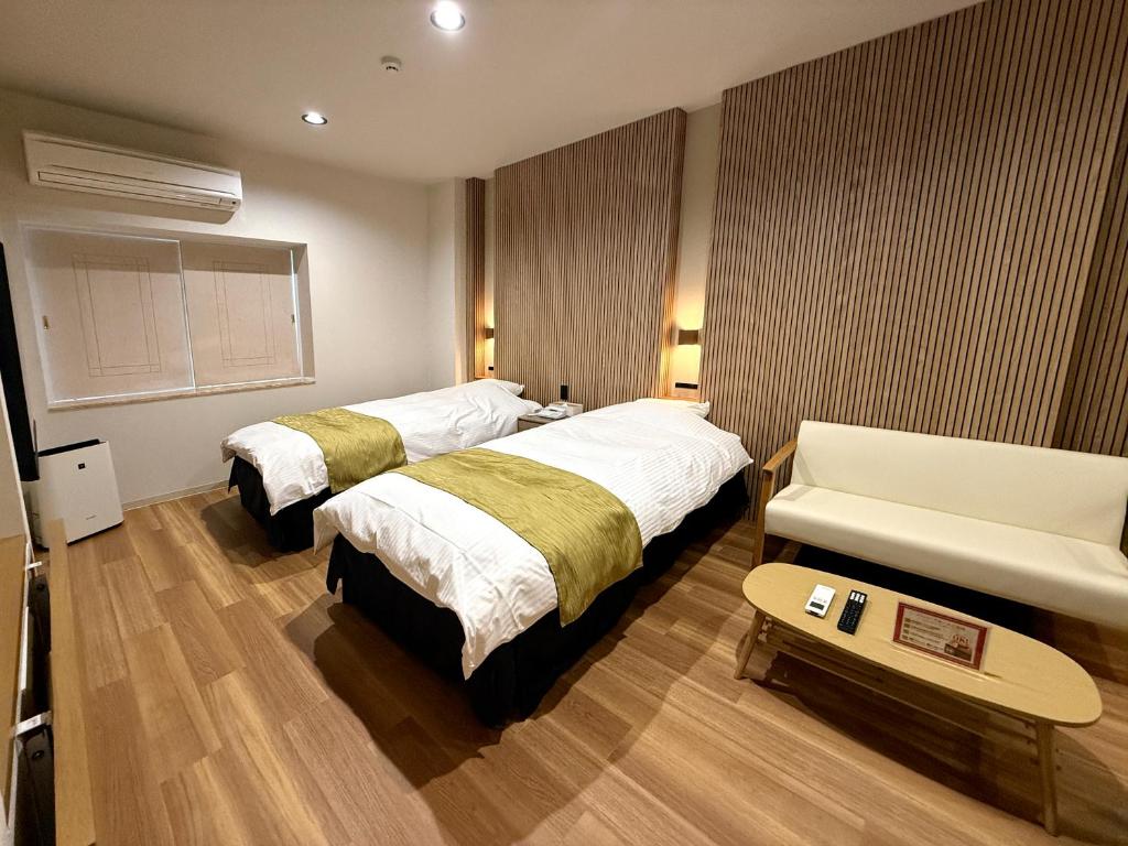 une chambre d'hôtel avec deux lits et un canapé dans l'établissement Hotel Hyper (Adult Only), à Osaka