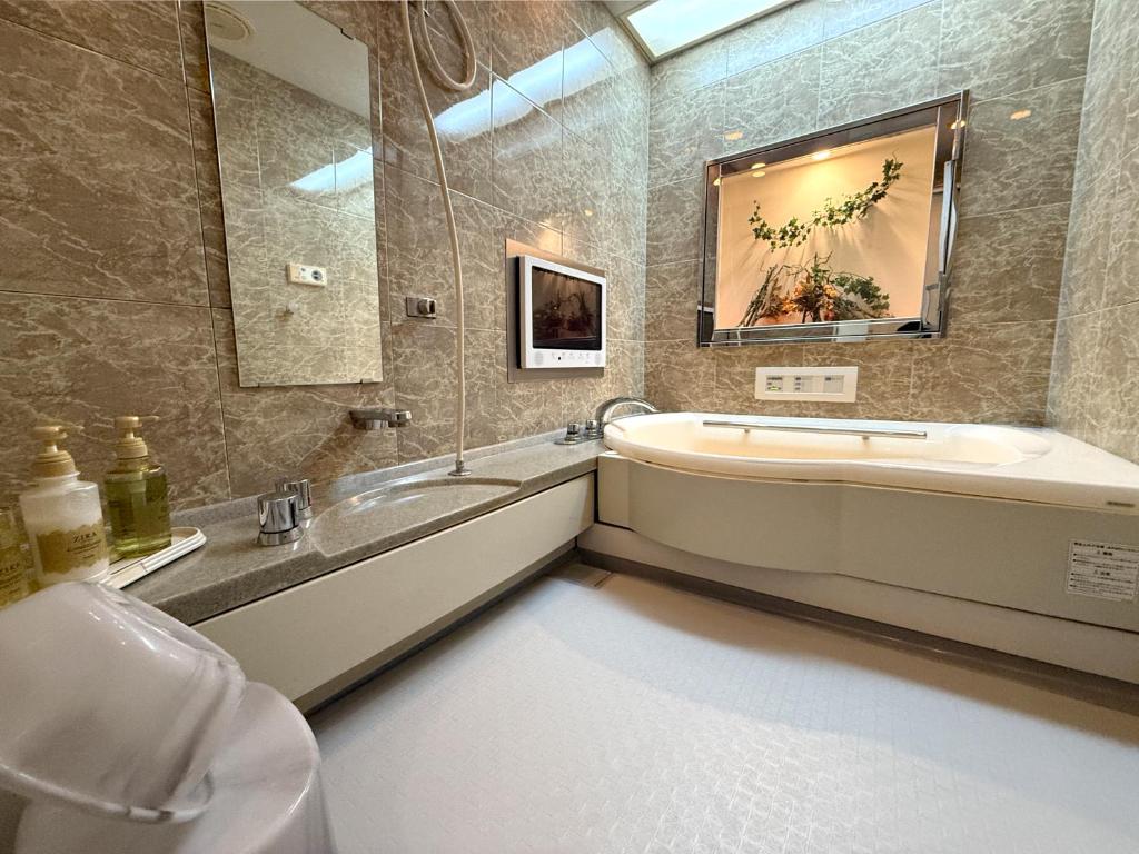 une salle de bain avec une baignoire, un lavabo et un miroir dans l'établissement Hotel Hyper (Adult Only), à Osaka