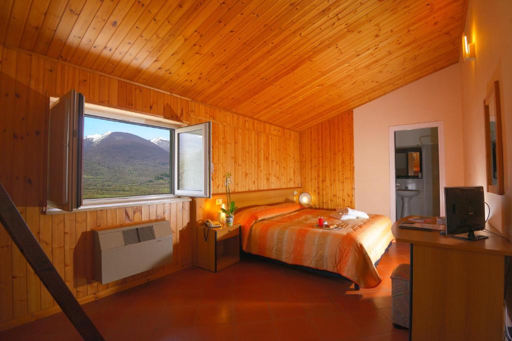 - une chambre avec un lit et une fenêtre donnant sur la montagne dans l'établissement HOTEL HOLIDAYS a Barrea - Natura, Relax e Benessere nel Parco d'Abruzzo, à Barrea