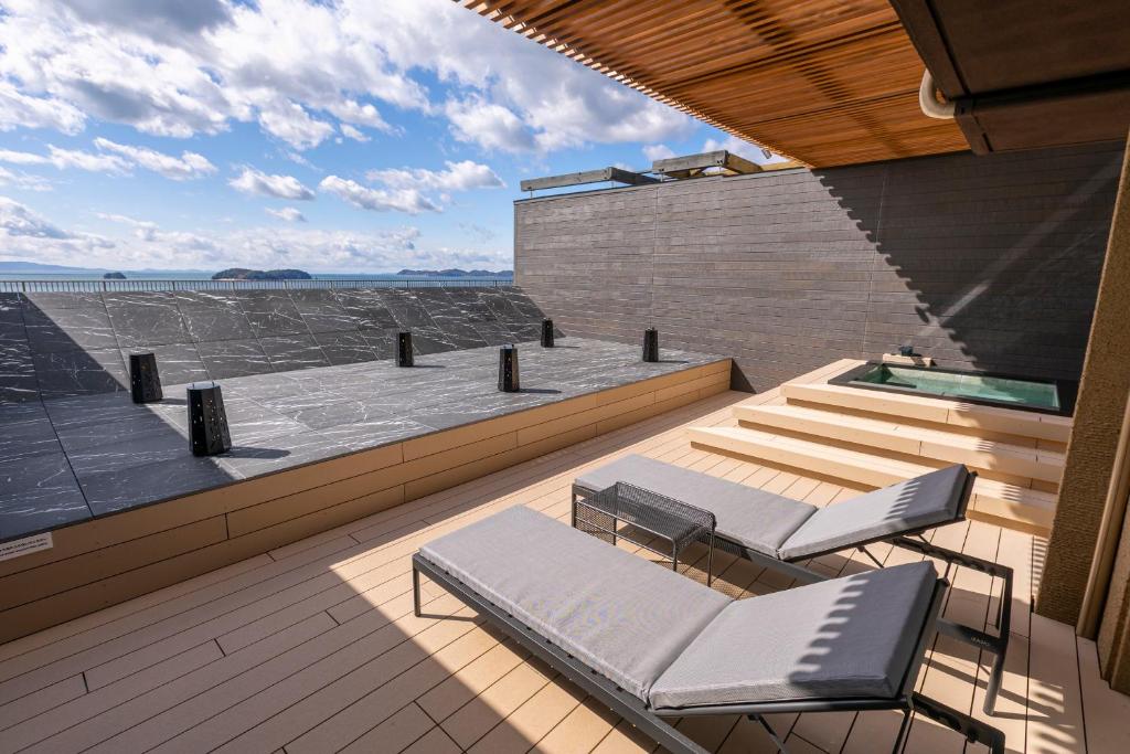 une terrasse avec deux chaises et une piscine dans l'établissement Hotel Meizanso, à Gamagori