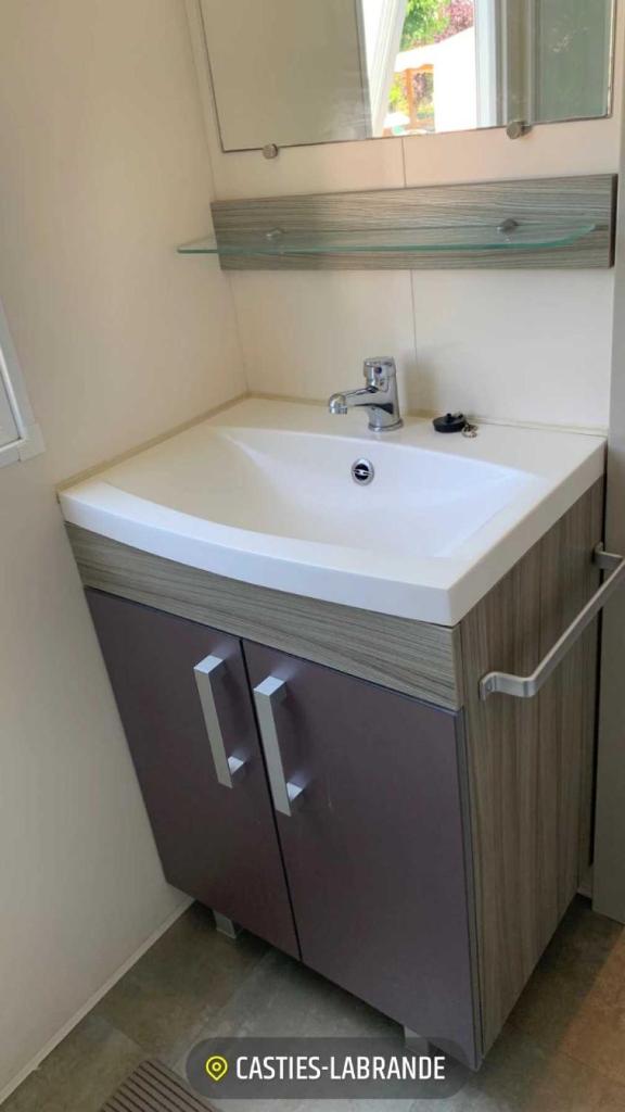 une salle de bain avec un lavabo blanc et un miroir dans l'établissement Camping 3 étoiles - Piscine - eehgef, à Castelnau-Picampeau