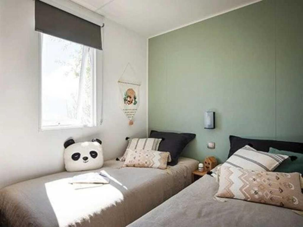 une chambre avec deux lits et une fenêtre dans l'établissement Camping 4 étoiles - Piscine - efchae, à Bourgneuf-en-Retz