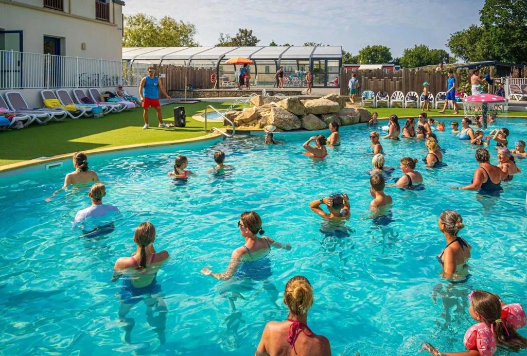 un groupe de personnes dans l'eau d'une piscine dans l'établissement Camping - Parc aquatique - ccafh0e, à Ambon