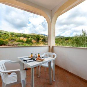 une table et des chaises dans une pièce avec une fenêtre dans l'établissement Seamoon Residence, à Marina di Camerota