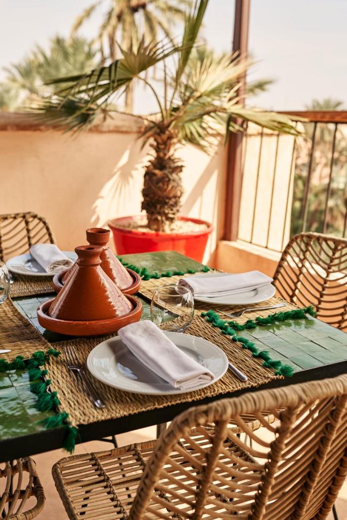une table en bois avec des assiettes et des serviettes dans l'établissement Riad Charaï, à Marrakech