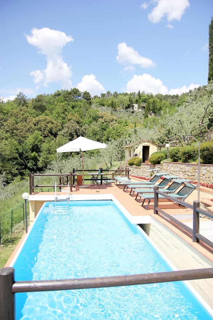 une piscine avec des chaises et un parasol dans l'établissement Tuscany Villa Chianti Hills - Villa Oliveta, à Loro Ciuffenna 34 autres photos
