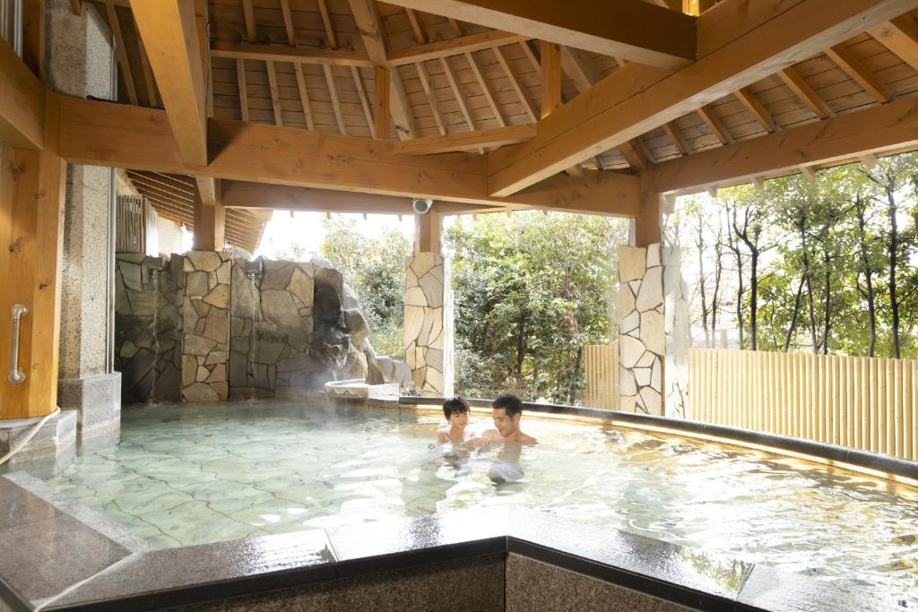 - deux enfants jouant dans une piscine dans l'établissement Ooedo Onsen Monogatari Premium Kaga Maruya, à Kaga