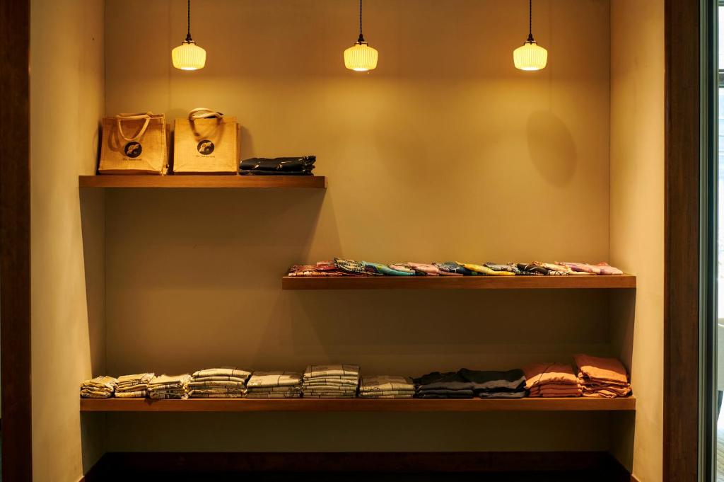 un placard avec trois étagères, des vêtements et des lumières dans l'établissement Shin Kaikatei Izumi, à Izu