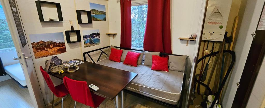 - une salle à manger avec une table et des oreillers rouges dans l'établissement mobil-home 43, à La Roque-dʼAnthéron