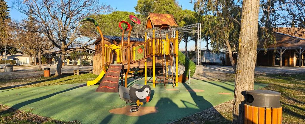 une aire de jeux avec un toboggan dans un parc dans l'établissement mobil-home 43, à La Roque-dʼAnthéron