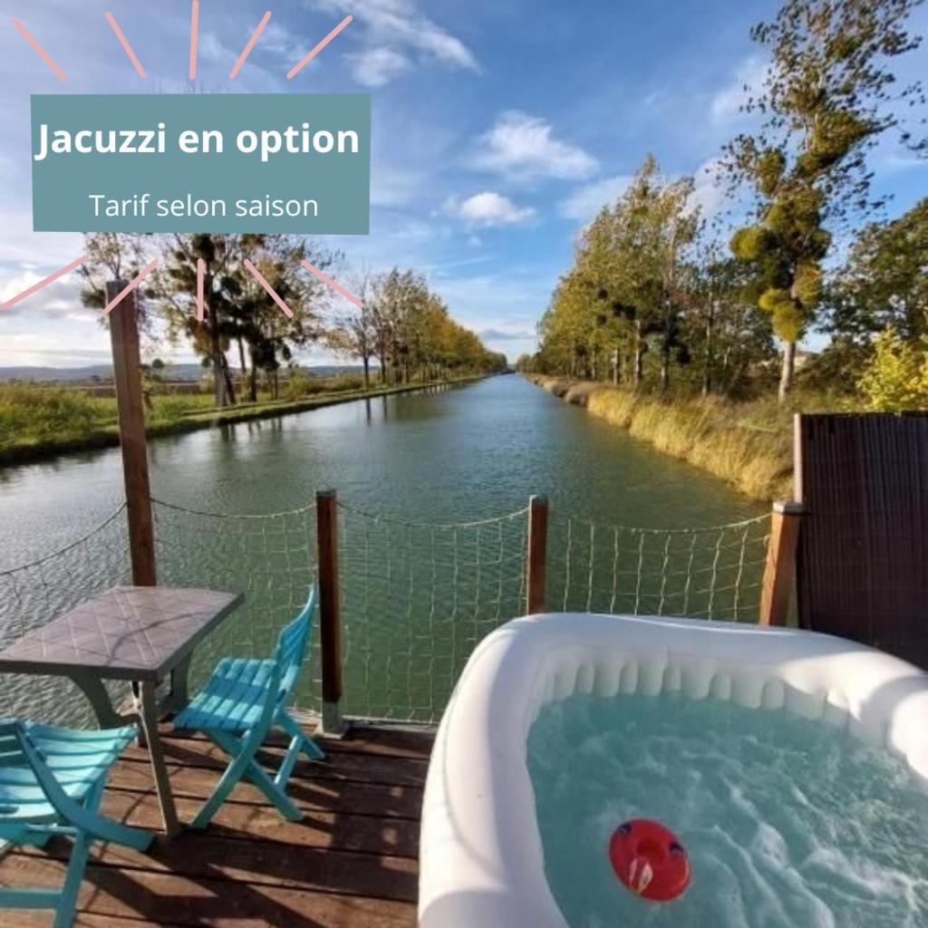 - un bain à remous sur une terrasse à côté d'une rivière dans l'établissement Cottage flottant terrasse jacuzzi option aux Portes de Dijon, à Ouges