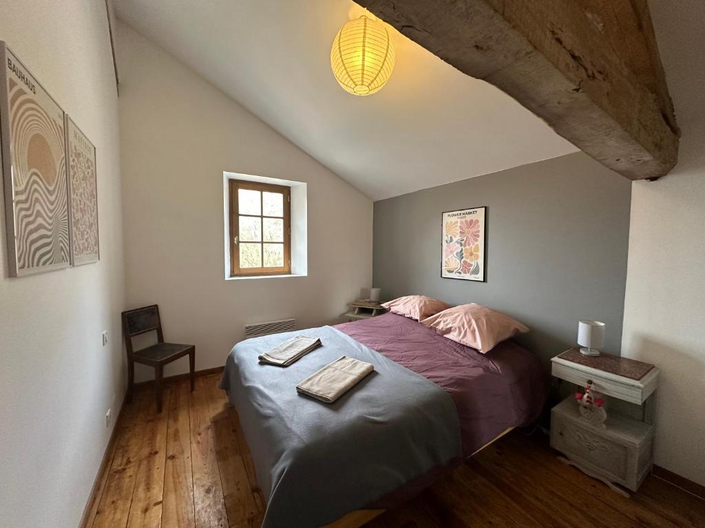 une chambre avec un lit avec une couette violette dans l'établissement Gîte à la Ferme de Verdurette Cordes-sur-Ciel, à Cordes-sur-Ciel