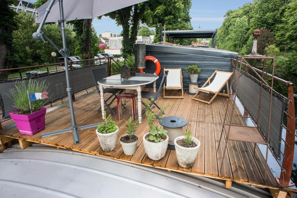 d'un balcon avec une table et des plantes en pot. dans l'établissement Péniche MaPensée, à Metz