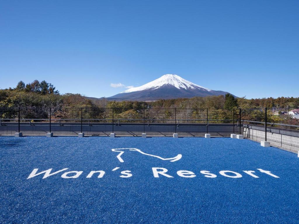 une vue d'une montagne enneigée avec un panneau au sol dans l'établissement Wan's Resort Yamanakako, à Yamanakako