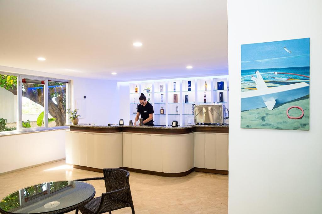 une femme debout à un comptoir dans une cuisine dans l'établissement Baia dei Mulini Resort & Spa, à Trapani 51 autres photos