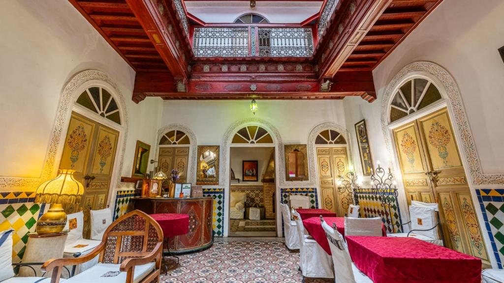 une salle à manger avec tables et chaises et un plafond dans l'établissement Riad Maison Arabo-Andalouse, à Marrakech
