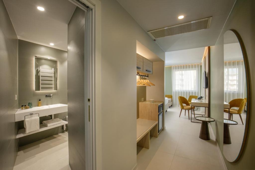 une cuisine et un salon avec un évier et un miroir dans l'établissement Ambasciatori Suite Hotel, à Sottomarina