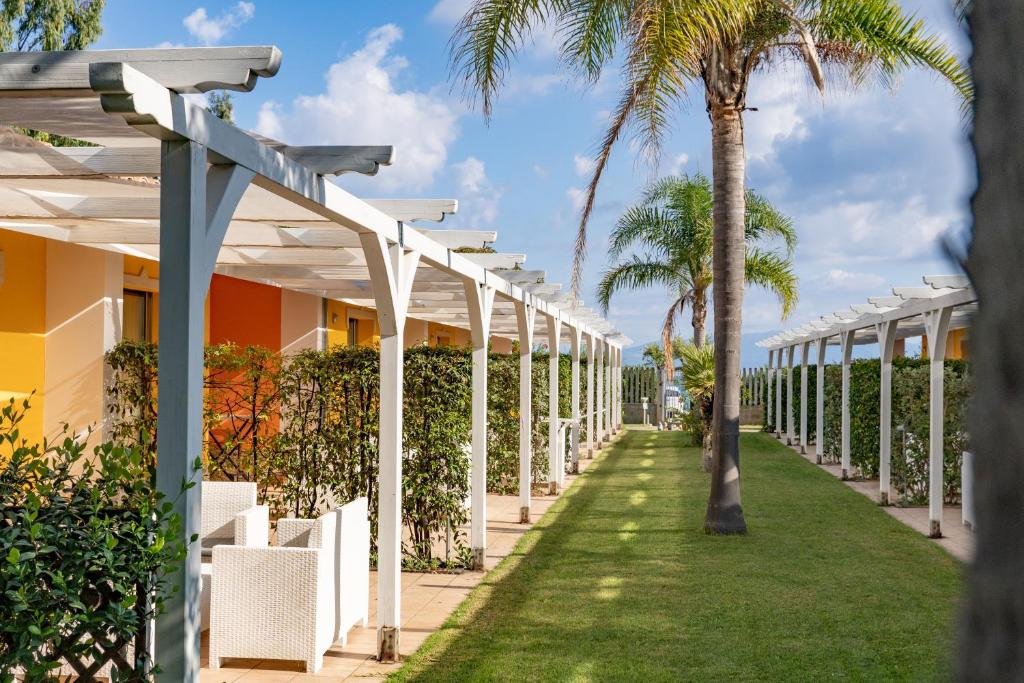 un chemin avec des palmiers devant un bâtiment dans l'établissement Hotel Baia Di Trainiti, à Vibo Valentia