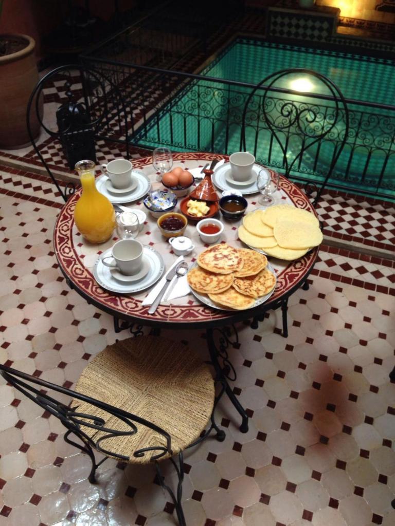 - une table avec de la nourriture pour le petit-déjeuner dans la chambre dans l'établissement Riad Mounlight, à Marrakech