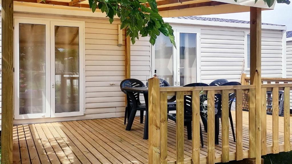 une terrasse en bois avec une table et des chaises dessus dans l'établissement Camping Tikayan Félix de la Bastide, à Saint-Mitre-les-Remparts