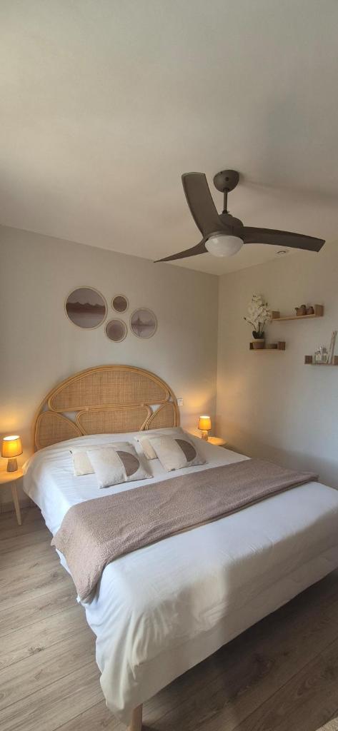 une chambre avec un grand lit avec un ventilateur de plafond dans l'établissement Gîte A l'ombre du clocher, à Calenzana