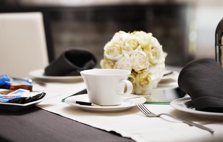 - une table avec une tasse de café et un bouquet de roses blanches dans l'établissement Gabri Park Hotel, à San Salvo