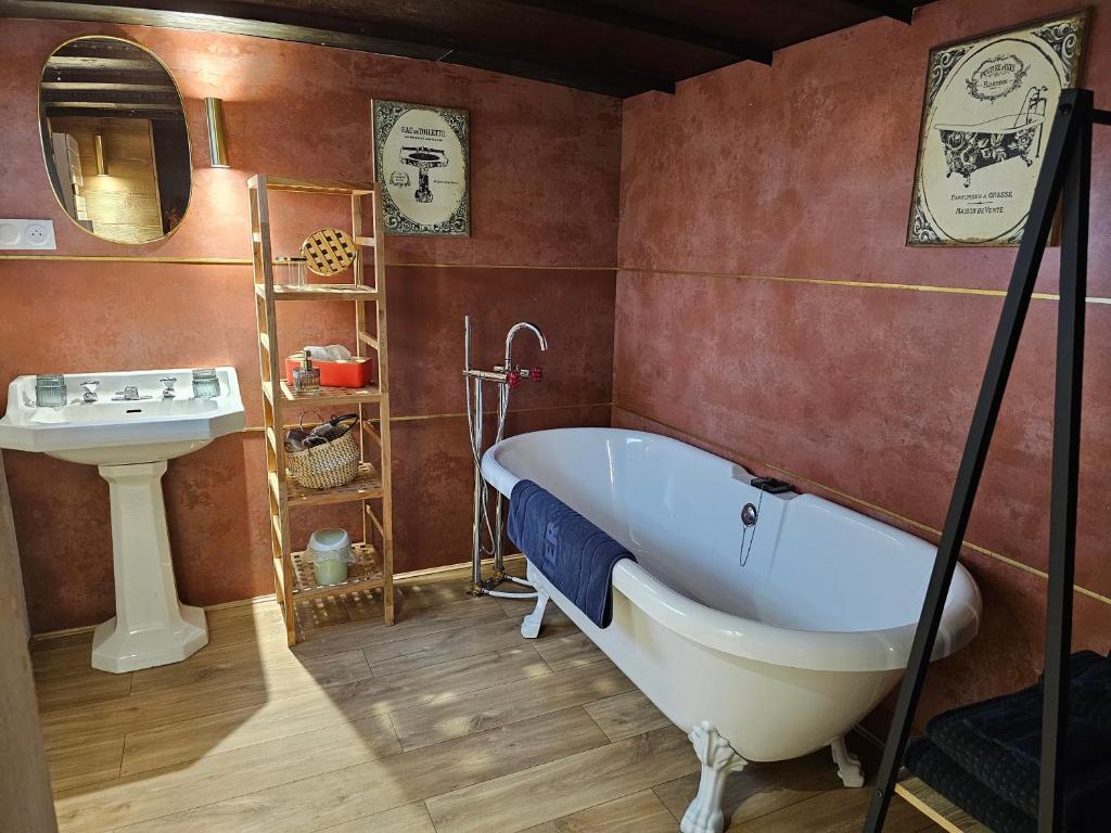 une salle de bain avec une baignoire blanche et un lavabo dans l'établissement La Péniche Mathurin - Gîte insolite sur l'eau, à Saint-Omer 22 autres photos