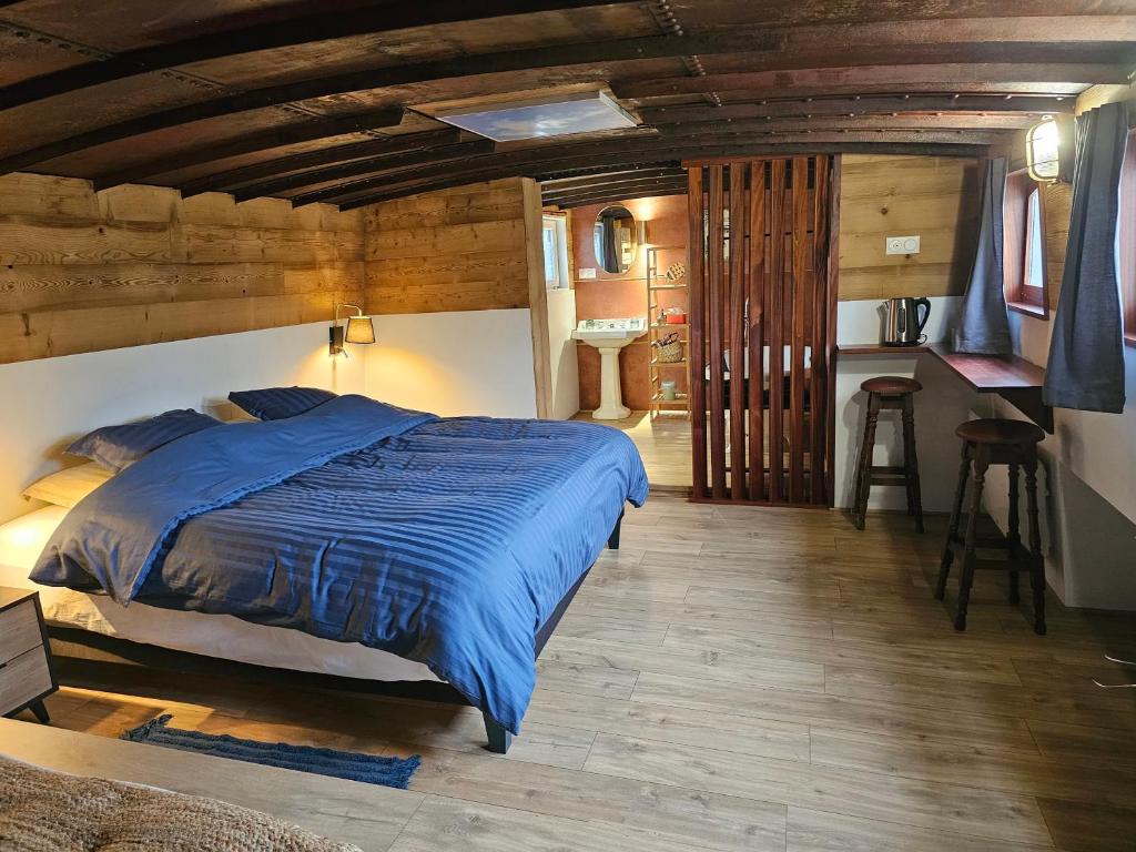 une chambre avec un lit avec un plafond en bois dans l'établissement La Péniche - Gîte de groupe insolite, à Saint-Omer