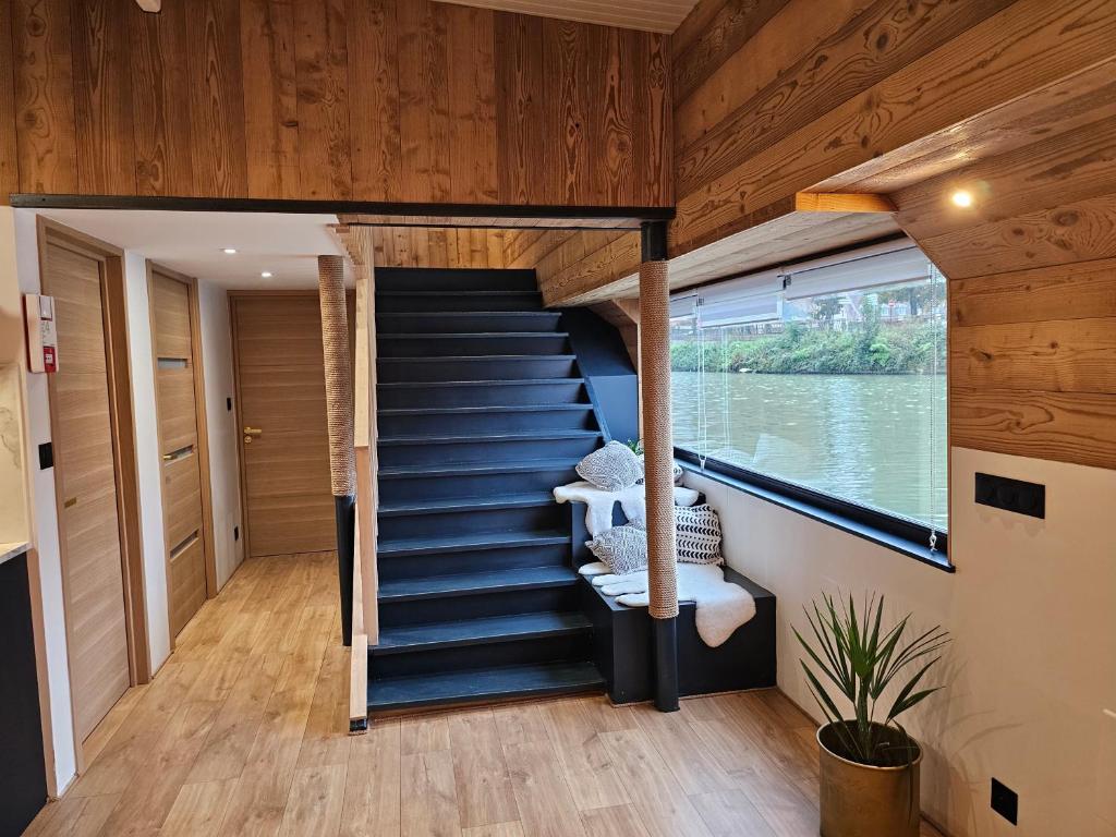une maison sur l'eau avec un escalier dans l'établissement La Péniche Mathurin - Gîte insolite sur l'eau, à Saint-Omer