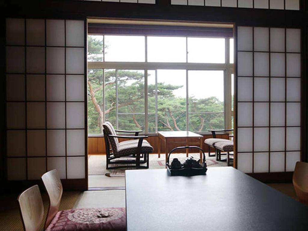 une pièce avec une table et des chaises et une grande fenêtre dans l'établissement Wakaki Ryokan - Nasu Yumoto Onsen, à Nasu