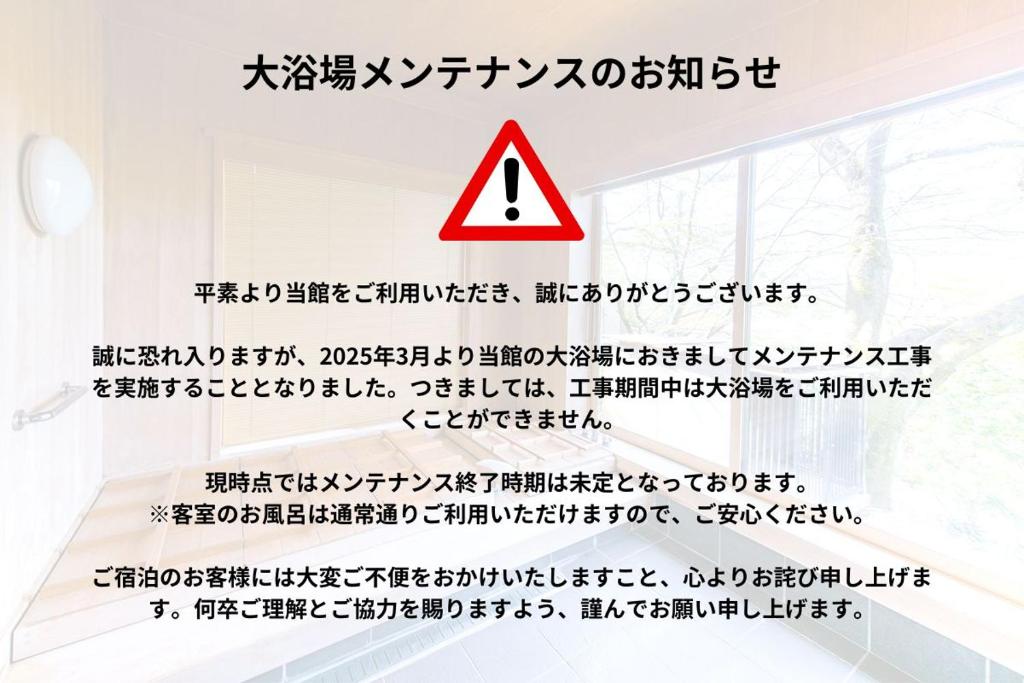un panneau de danger sur le mur d'une pièce avec écriture dans l'établissement Oukai Villa Izumi, à Izumi