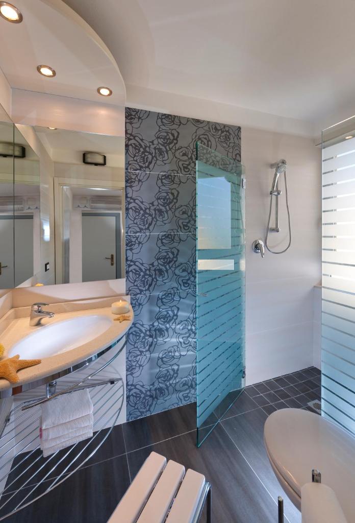 une salle de bain avec un lavabo et une douche dans l'établissement Hotel Gabriella, à Rimini