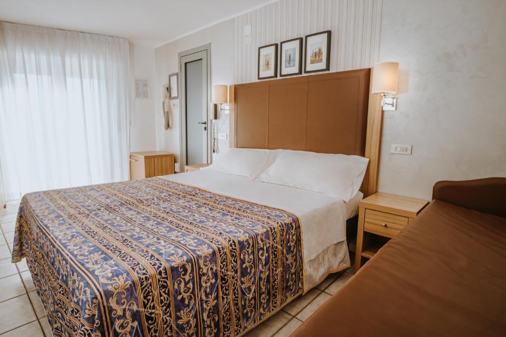 une chambre d'hôtel avec un grand lit et une fenêtre dans l'établissement Hotel Gabriella, à Rimini 49 autres photos