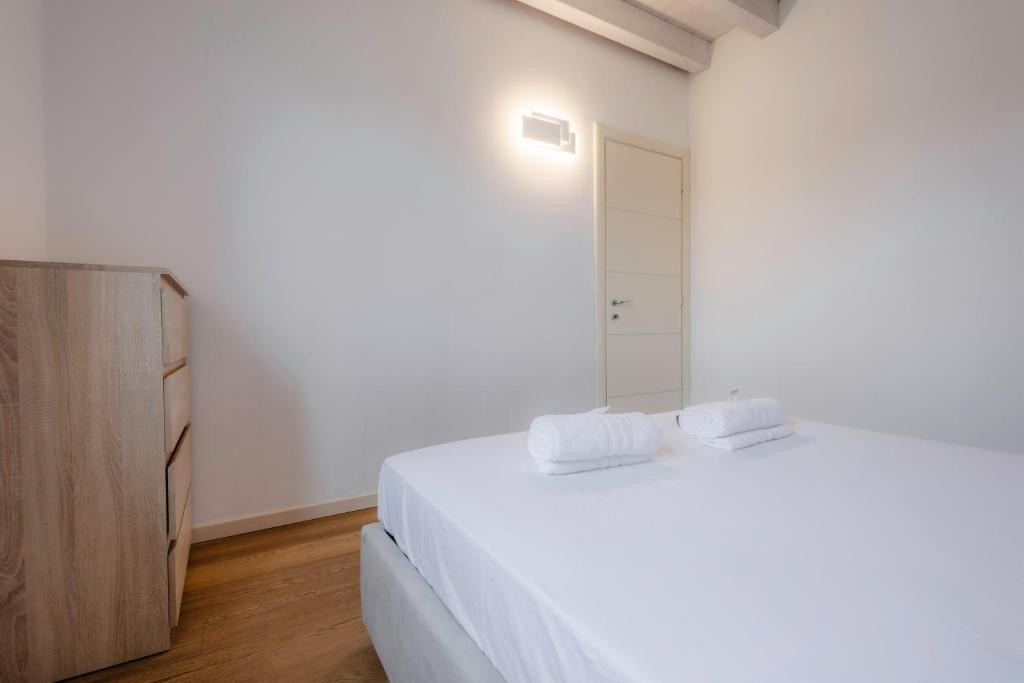 une chambre blanche avec un lit et un miroir dans l'établissement Oasi Dolci Colli, à Ponti sul Mincio