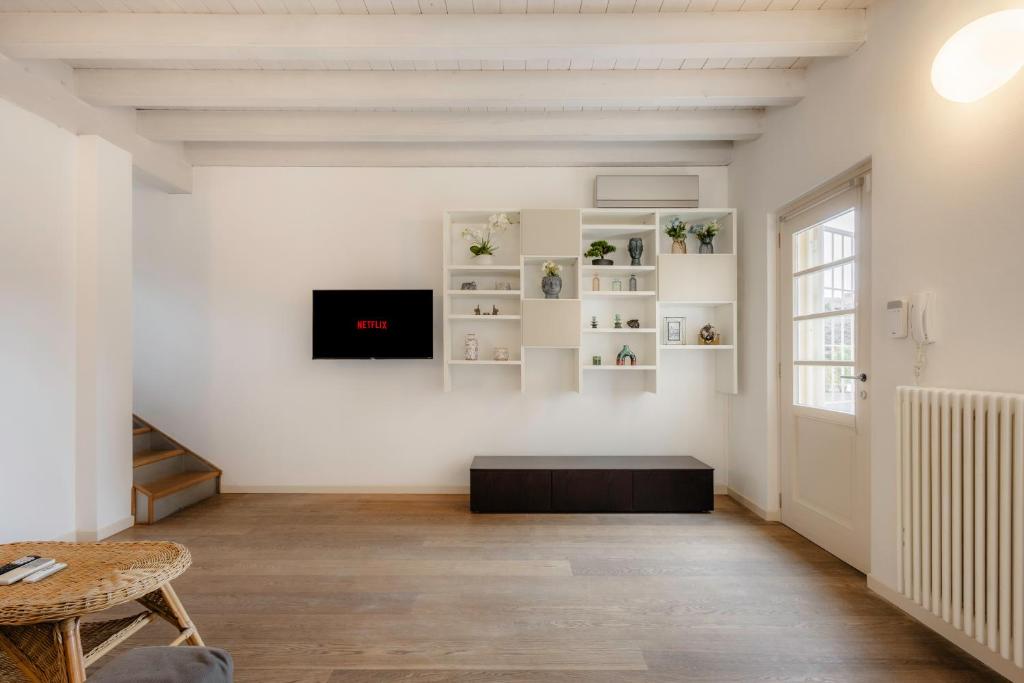 un salon avec une table et une télévision au mur dans l'établissement Oasi Dolci Colli, à Ponti sul Mincio