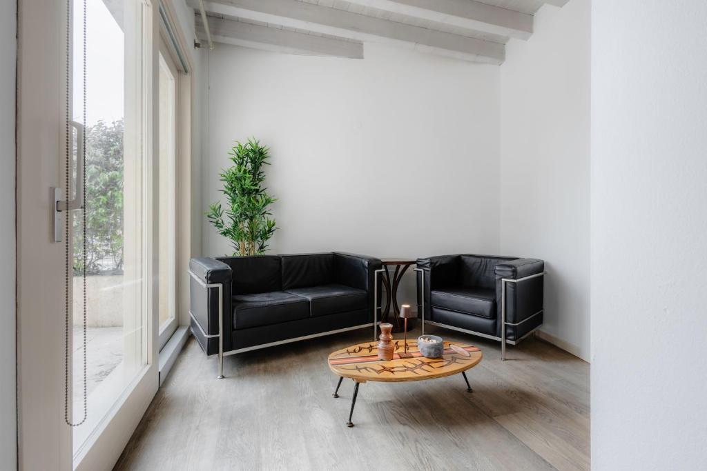 - un salon avec deux canapés en cuir noir et une table dans l'établissement Oasi Dolci Colli, à Ponti sul Mincio