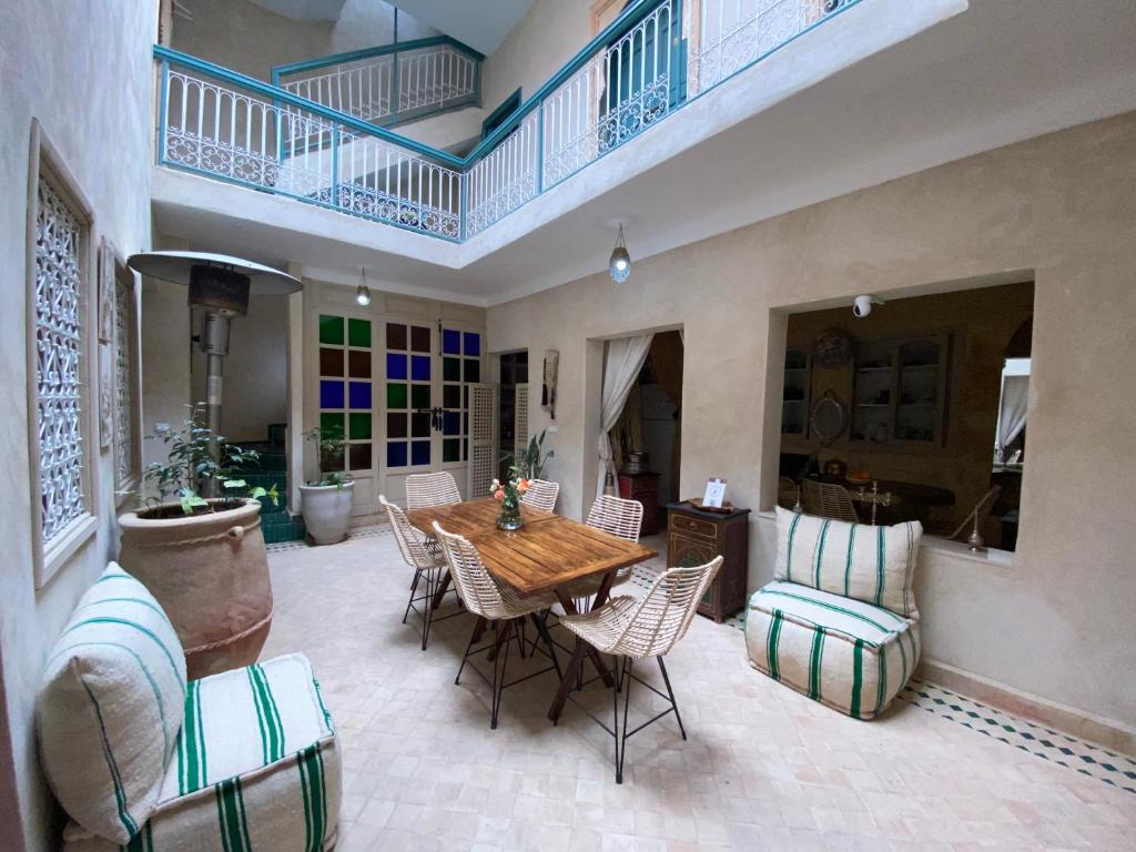 Cette grande chambre dispose d'une table et de chaises en bois. dans l'établissement Riad 7 Saints, à Marrakech