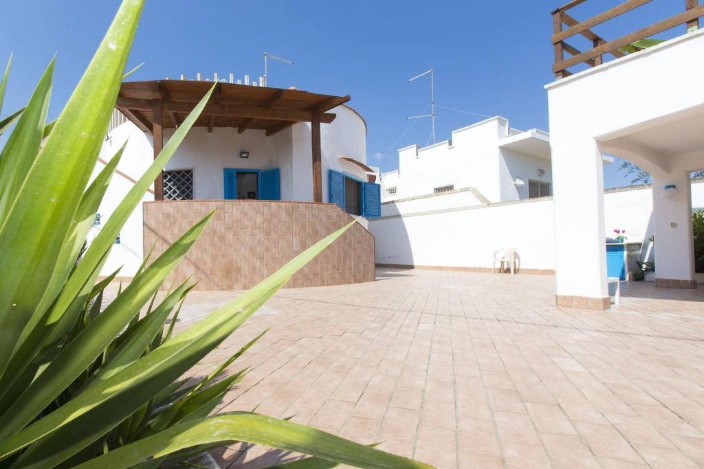- une vue sur la cour d'une maison dans l'établissement Villa Azzurra con piscina e con vista mare fronte Spiaggia Specchiarica di San Pietro in Bevagna, à Torre Colimena