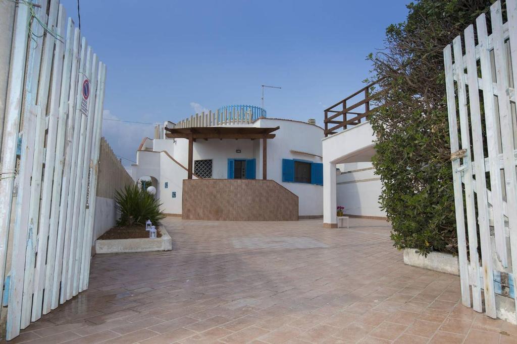 - une vue sur une maison depuis l'allée dans l'établissement Villa Azzurra con piscina e con vista mare fronte Spiaggia Specchiarica di San Pietro in Bevagna, à Torre Colimena