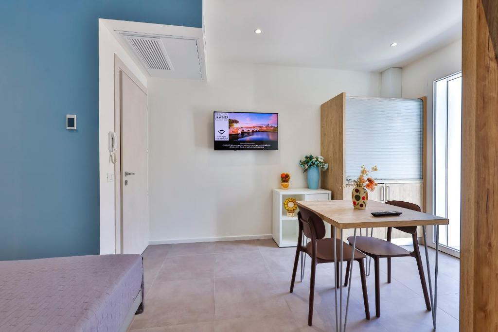 une chambre avec un lit, une table et des chaises dans l'établissement Apho Apartment Hotel, à Rimini