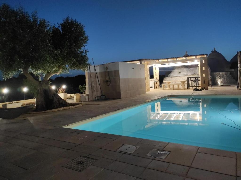 une piscine devant une maison la nuit dans l'établissement Trulli LENUCCIA villa, à Ceglie Messapica