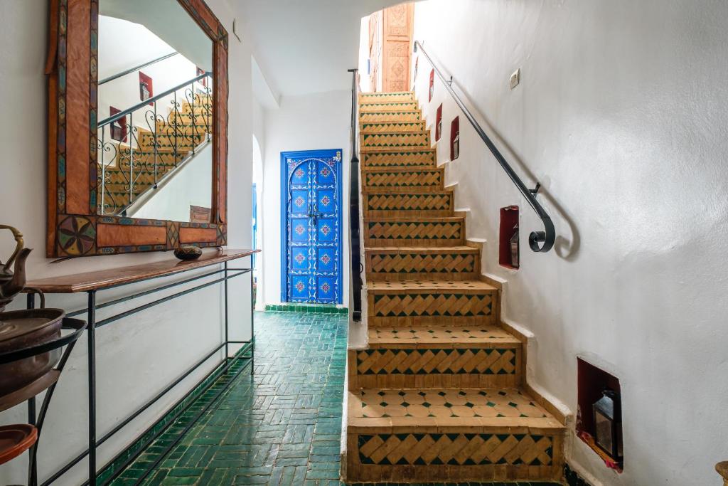 - un escalier dans un bâtiment avec un miroir et une porte dans l'établissement Riad Bobby Marrakech, à Marrakech