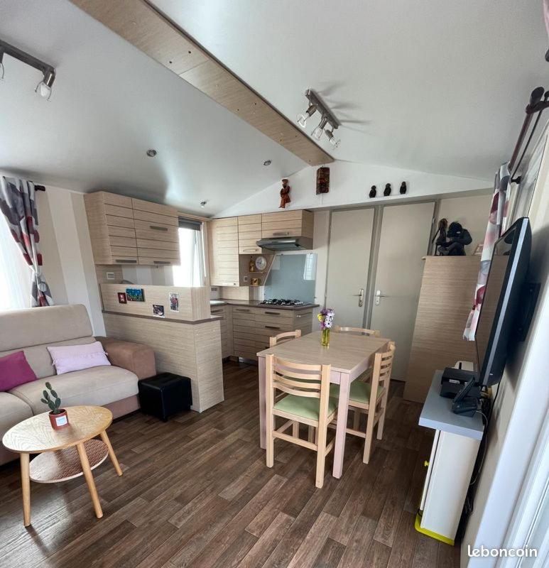 un petit salon avec une table et un canapé dans l'établissement mobil home de luxe, au Pradet 2 autres photos