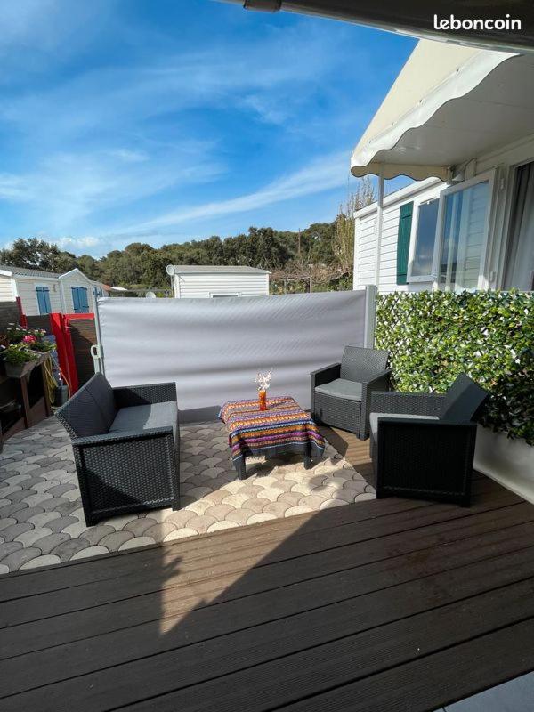 un patio avec deux chaises et une table sur une terrasse dans l'établissement mobil home de luxe, au Pradet