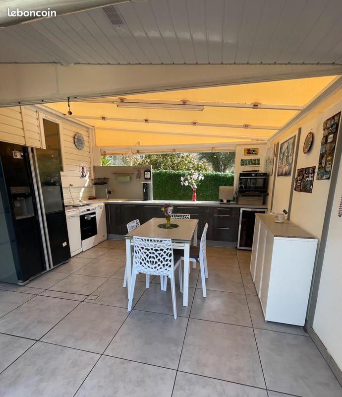 une cuisine avec une table et des chaises dans une cuisine dans l'établissement mobil home de luxe, au Pradet