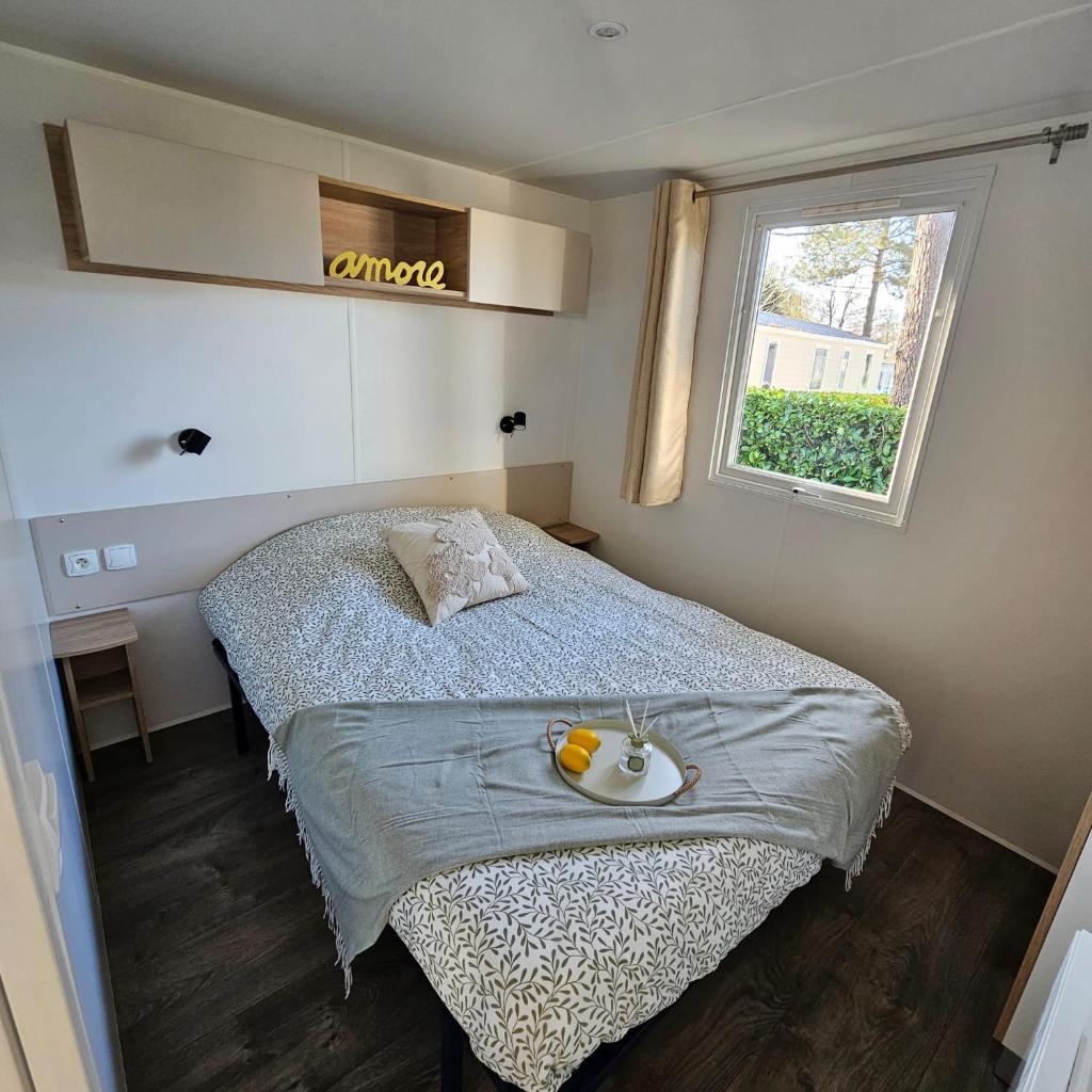 une chambre avec un lit avec un bol de fruits dessus dans l'établissement Mobil-home 4-6 pers - Terrasse & Linge - Domaine de Kerlann, à Pont-Aven