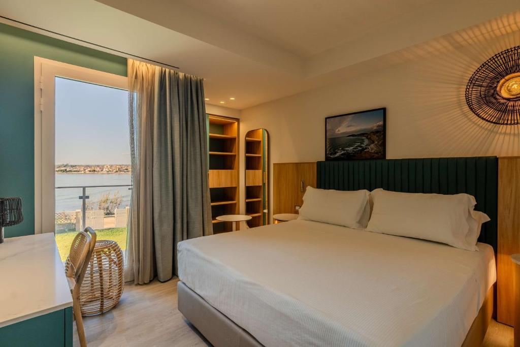 une chambre avec un grand lit et une grande fenêtre dans l'établissement Terradamari Resort & Spa Marina di Modica,Tapestry by Hilton, à Marina di Modica