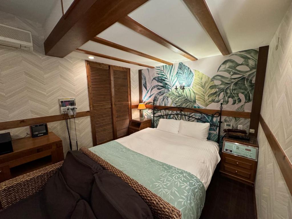 une chambre avec un lit avec un tableau sur le mur dans l'établissement LaLa Resort (Adult Only), à Kobe