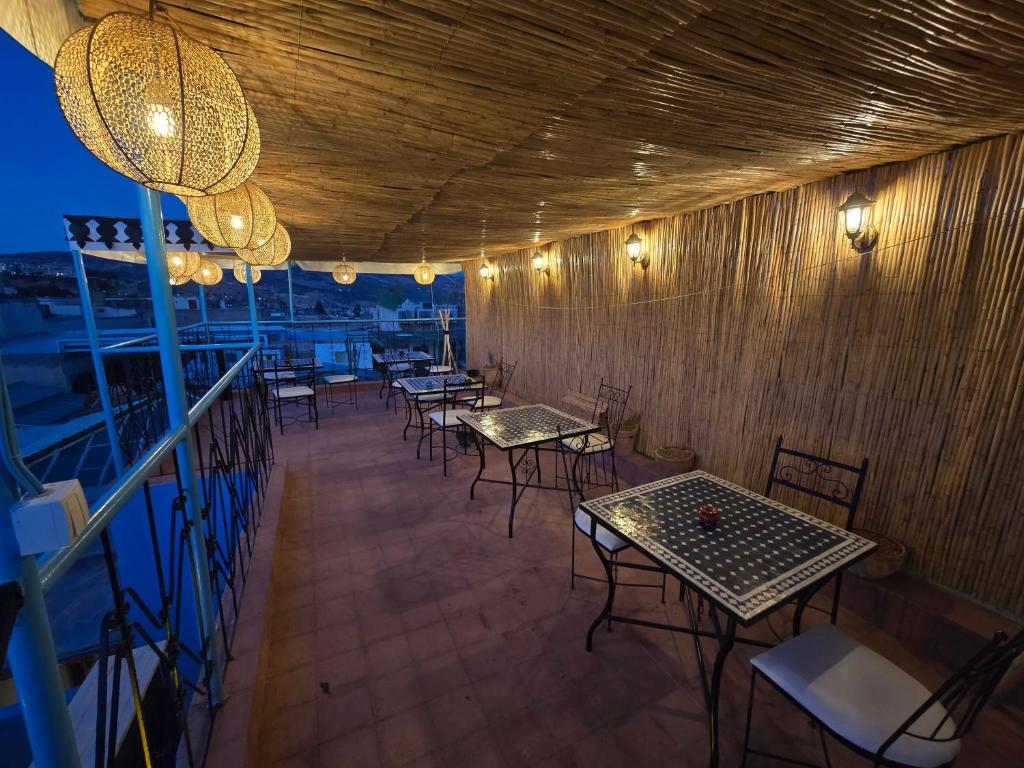 un restaurant avec des tables et des chaises sur une terrasse dans l'établissement Riad Mounadim Fes, à Fès