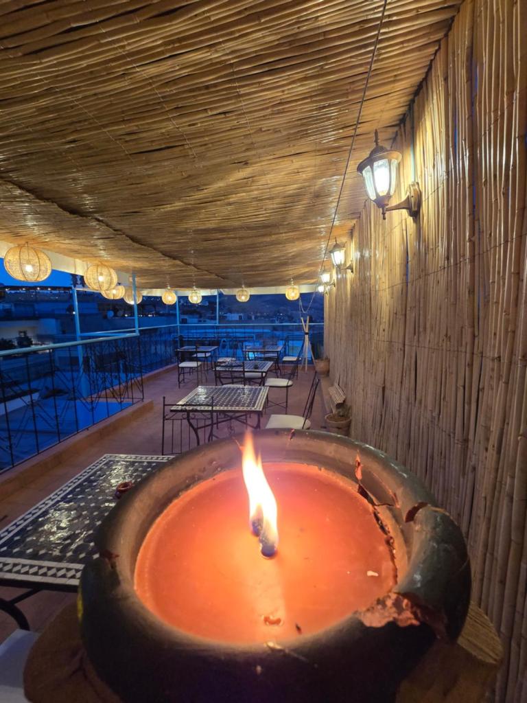 - un foyer extérieur dans une pièce avec une table dans l'établissement Riad Mounadim Fes, à Fès